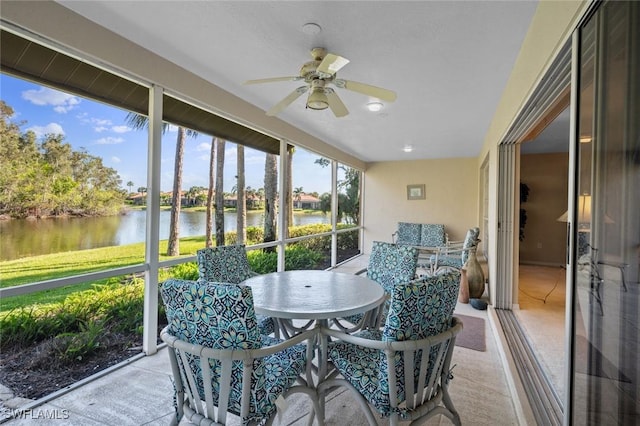 sunroom / solarium with a water view and ceiling fan