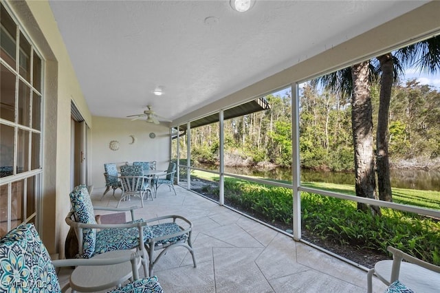 unfurnished sunroom with ceiling fan