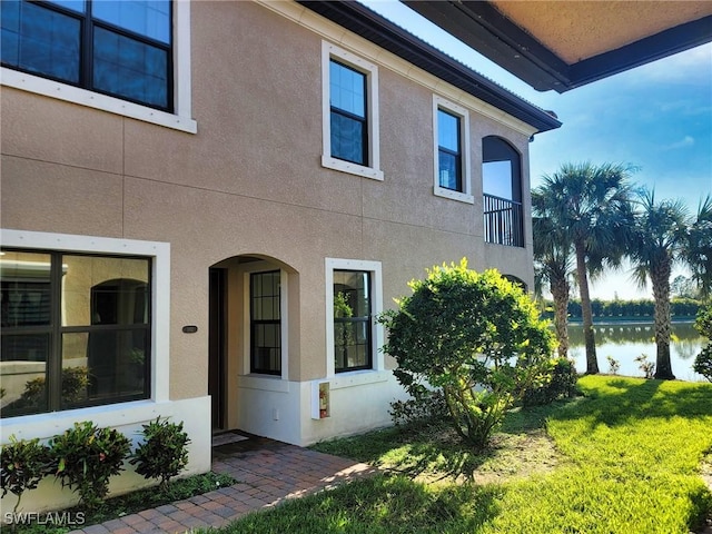 view of property exterior featuring a lawn and a balcony