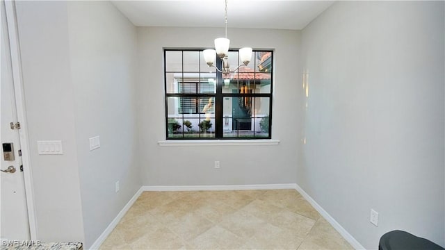 unfurnished dining area with baseboards and a chandelier