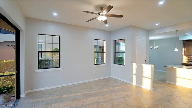 spare room featuring recessed lighting, baseboards, light tile patterned flooring, and ceiling fan with notable chandelier