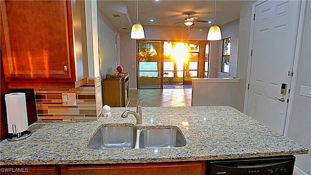 kitchen featuring backsplash, dishwasher, a sink, light stone countertops, and ceiling fan