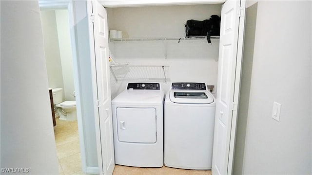 laundry room with washing machine and clothes dryer, laundry area, and light tile patterned floors