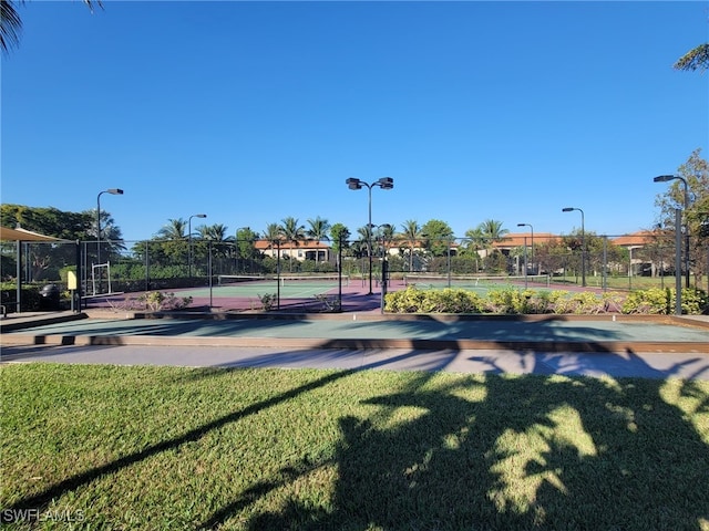 view of home's community with a yard and tennis court