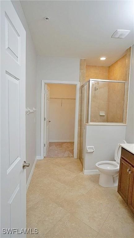 full bathroom featuring a shower stall, tile patterned floors, a spacious closet, vanity, and toilet