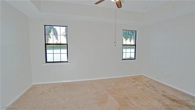spare room with carpet, baseboards, a wealth of natural light, and ceiling fan