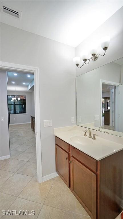 bathroom with visible vents, tile patterned floors, vanity, and a notable chandelier
