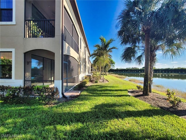 view of yard featuring a balcony and a water view
