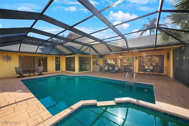 view of swimming pool featuring glass enclosure and a patio