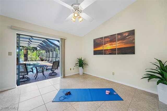 exercise area with tile patterned flooring, vaulted ceiling, and ceiling fan