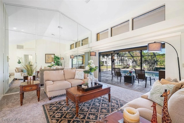 living room with a high ceiling and carpet floors