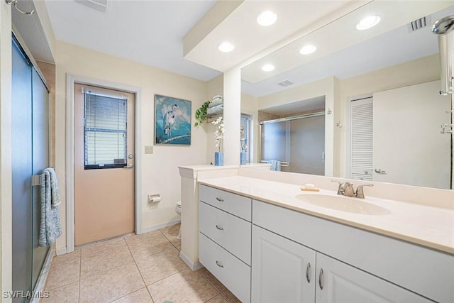 bathroom featuring tile patterned floors, vanity, toilet, and an enclosed shower