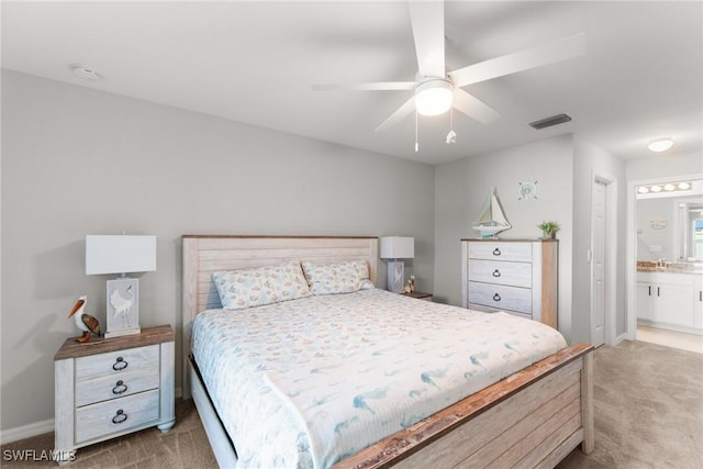 carpeted bedroom featuring ensuite bathroom, ceiling fan, and sink