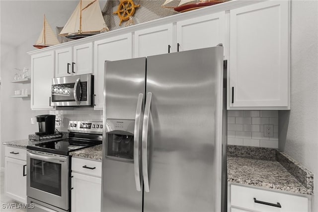 kitchen with decorative backsplash, white cabinetry, and stainless steel appliances