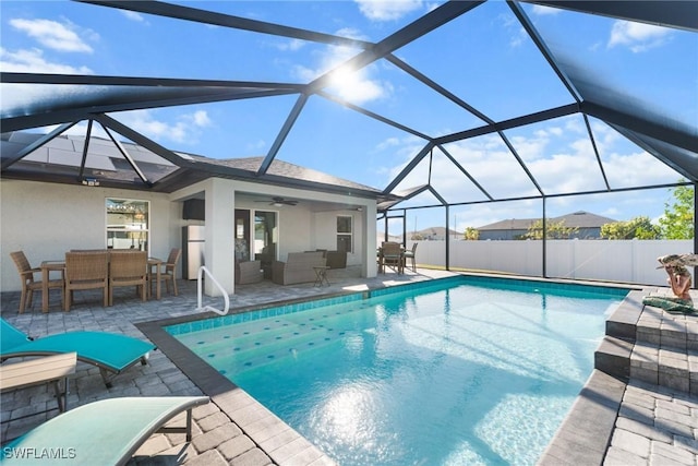 view of pool with outdoor lounge area, a lanai, ceiling fan, and a patio area