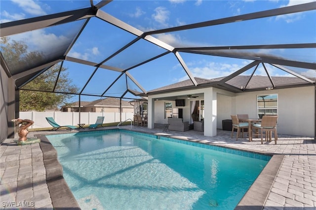 view of pool featuring ceiling fan, a patio area, and glass enclosure