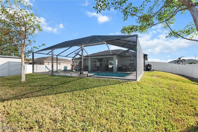 rear view of property with a fenced in pool, glass enclosure, and a lawn