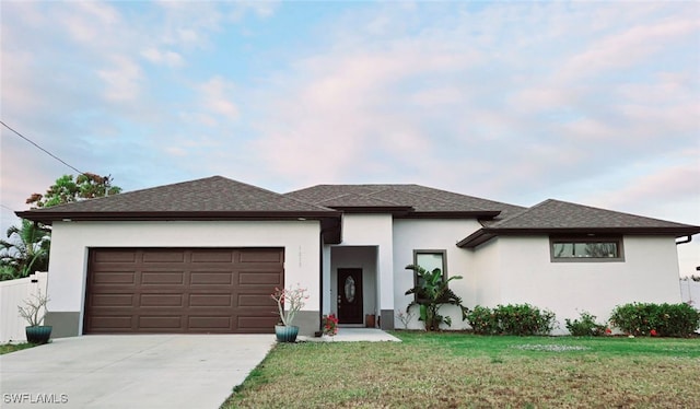 prairie-style home with a garage and a front lawn