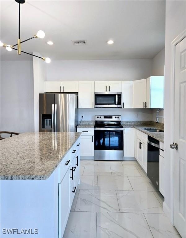 kitchen featuring a sink, visible vents, white cabinets, marble finish floor, and appliances with stainless steel finishes