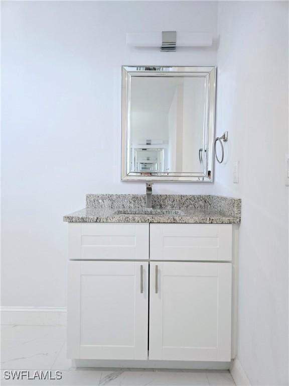 bathroom featuring marble finish floor, vanity, and baseboards