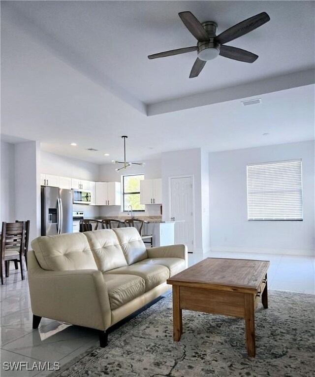 living room with ceiling fan with notable chandelier