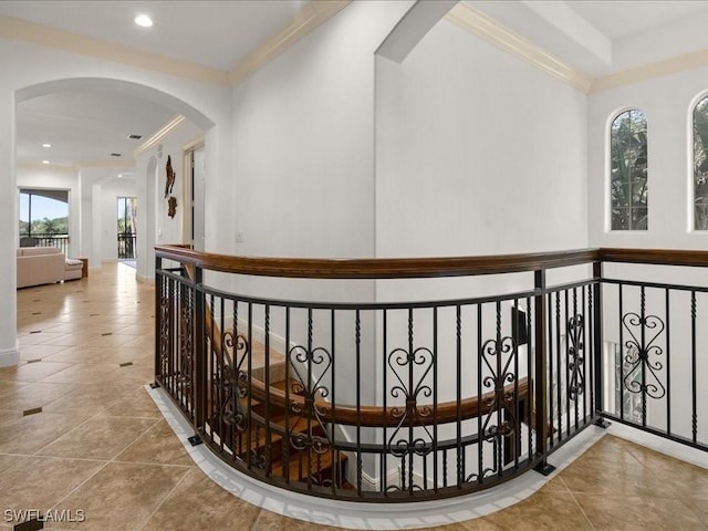 hallway with light tile patterned floors, a wealth of natural light, and crown molding