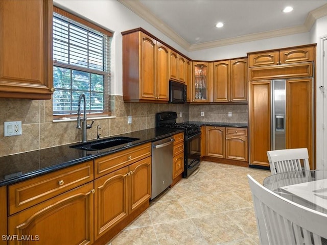 kitchen with dark stone countertops, crown molding, sink, and appliances with stainless steel finishes