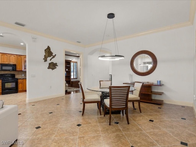 dining space with ornamental molding and light tile patterned floors