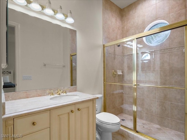 bathroom with vanity, toilet, and a shower with shower door