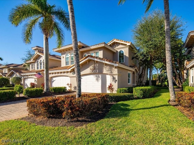 mediterranean / spanish-style home with a front lawn and a garage