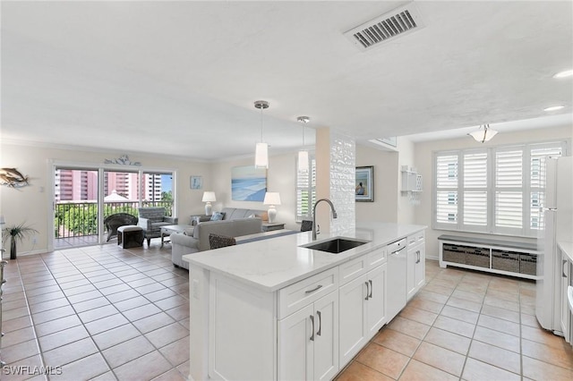 kitchen with hanging light fixtures, white cabinetry, sink, and a healthy amount of sunlight