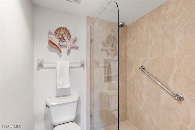 bathroom with toilet and tiled shower