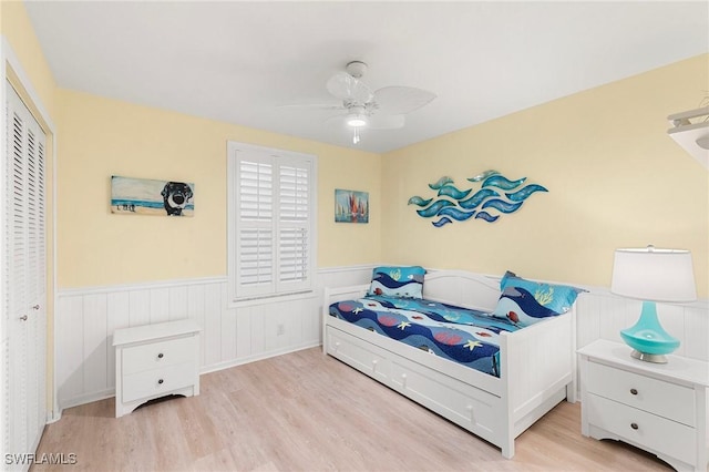 bedroom with light wood-type flooring, a closet, and ceiling fan