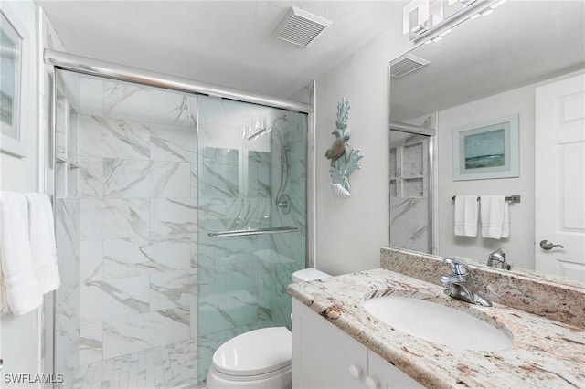 bathroom with vanity, toilet, and a shower with shower door