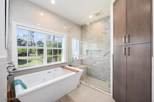 bathroom featuring tile patterned floors, separate shower and tub, and tile walls