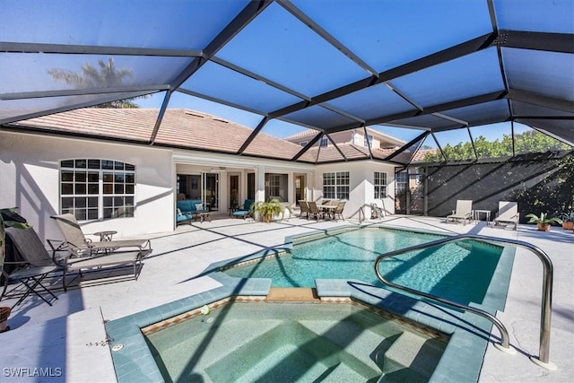 view of pool with an in ground hot tub, a patio, and glass enclosure