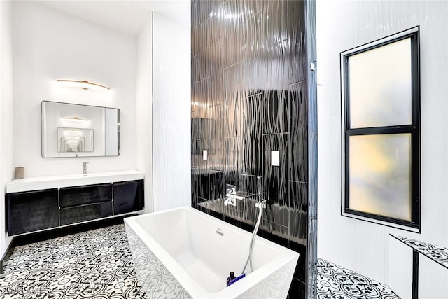 bathroom featuring tile patterned floors, tiled bath, and vanity