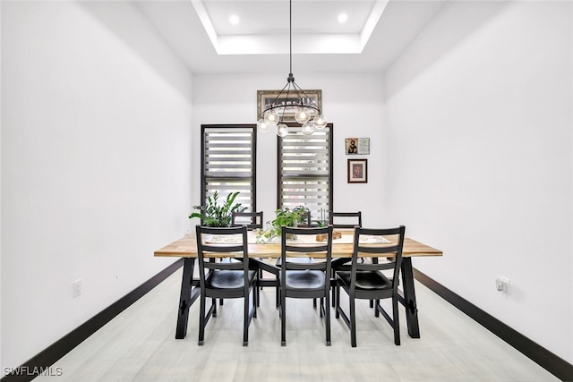 dining area featuring a tray ceiling and an inviting chandelier