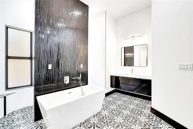 bathroom with a bathing tub, tile patterned flooring, tile walls, and vanity