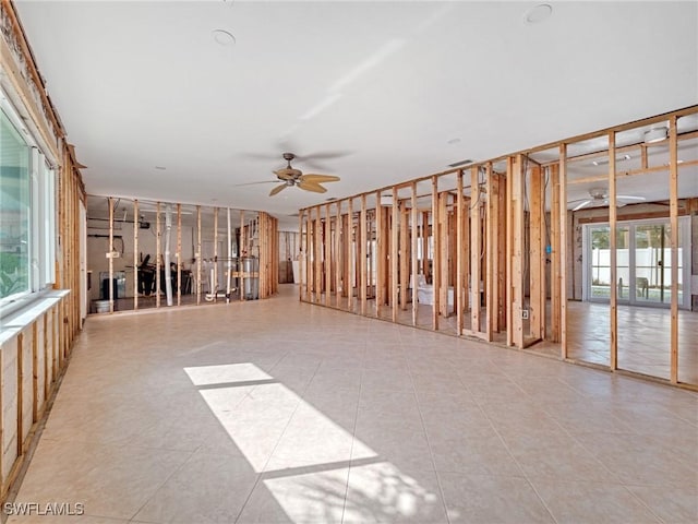 miscellaneous room featuring ceiling fan, light tile patterned floors, and a healthy amount of sunlight