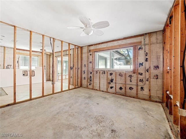 miscellaneous room featuring ceiling fan, concrete flooring, and a wealth of natural light