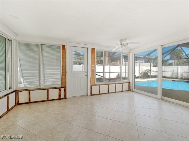 unfurnished sunroom featuring ceiling fan