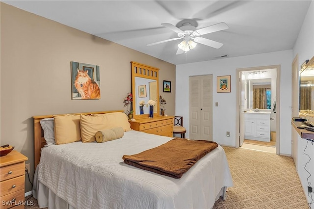 bedroom with connected bathroom, a closet, ceiling fan, and light colored carpet