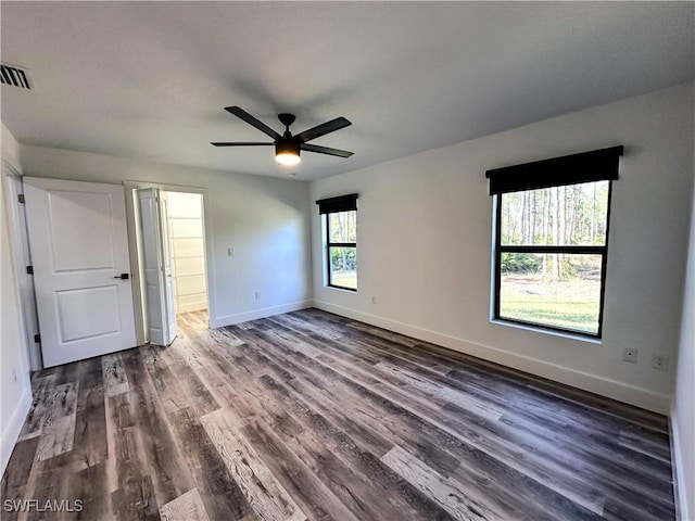 unfurnished bedroom featuring ceiling fan and dark wood-type flooring