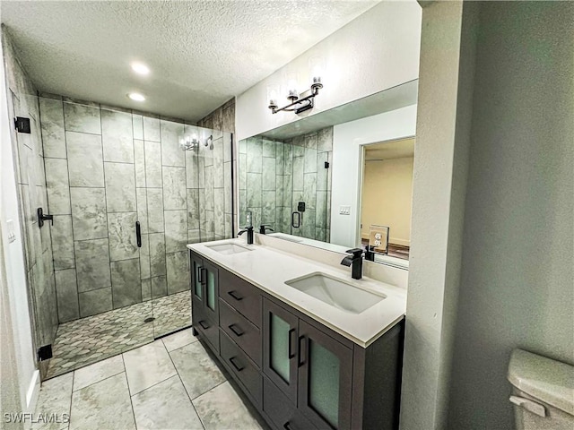 bathroom featuring tile patterned flooring, vanity, a shower with shower door, and a textured ceiling