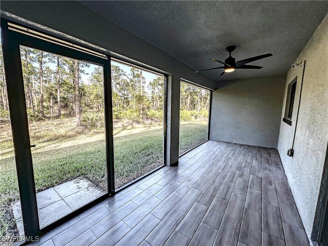 unfurnished sunroom featuring a wealth of natural light and ceiling fan