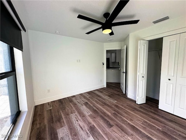 unfurnished bedroom featuring dark hardwood / wood-style flooring, a closet, and ceiling fan