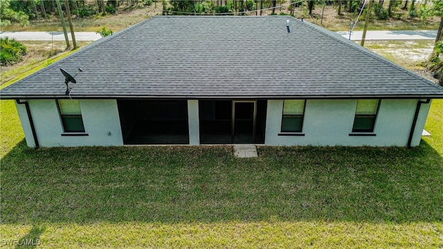 rear view of property featuring a lawn