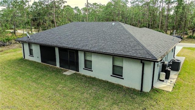 rear view of property with a yard and central AC unit