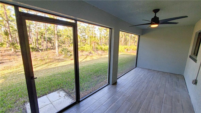 unfurnished sunroom with ceiling fan